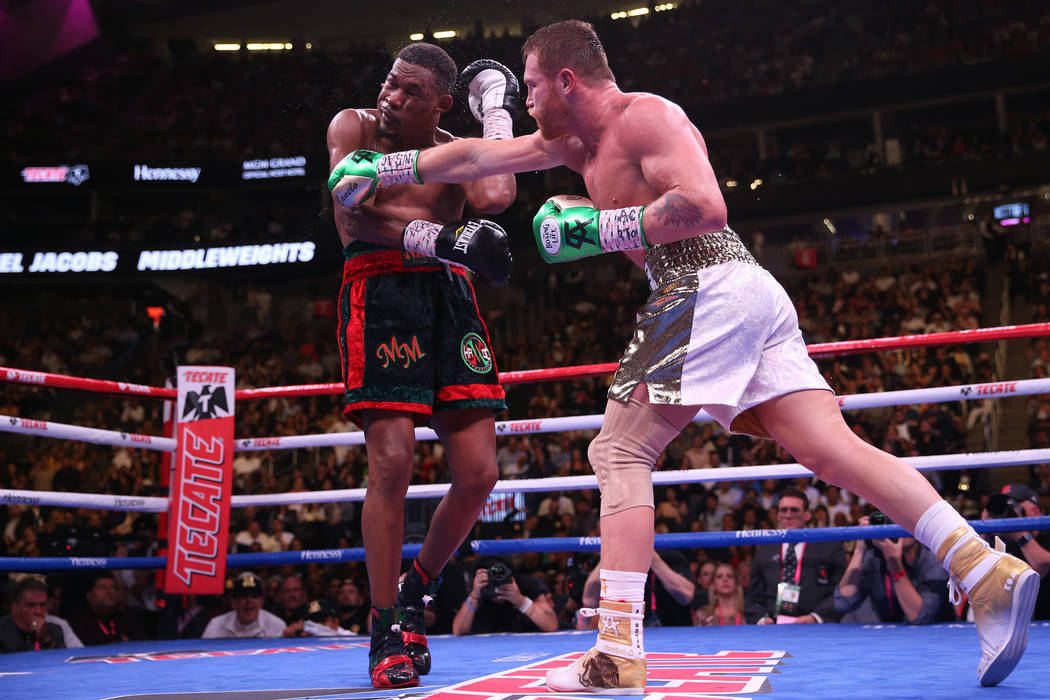 Saul Canelo Alvarez, right, connects a punch against Daniel Jacobs in the WBC, WBA, IBF, and Ri ...