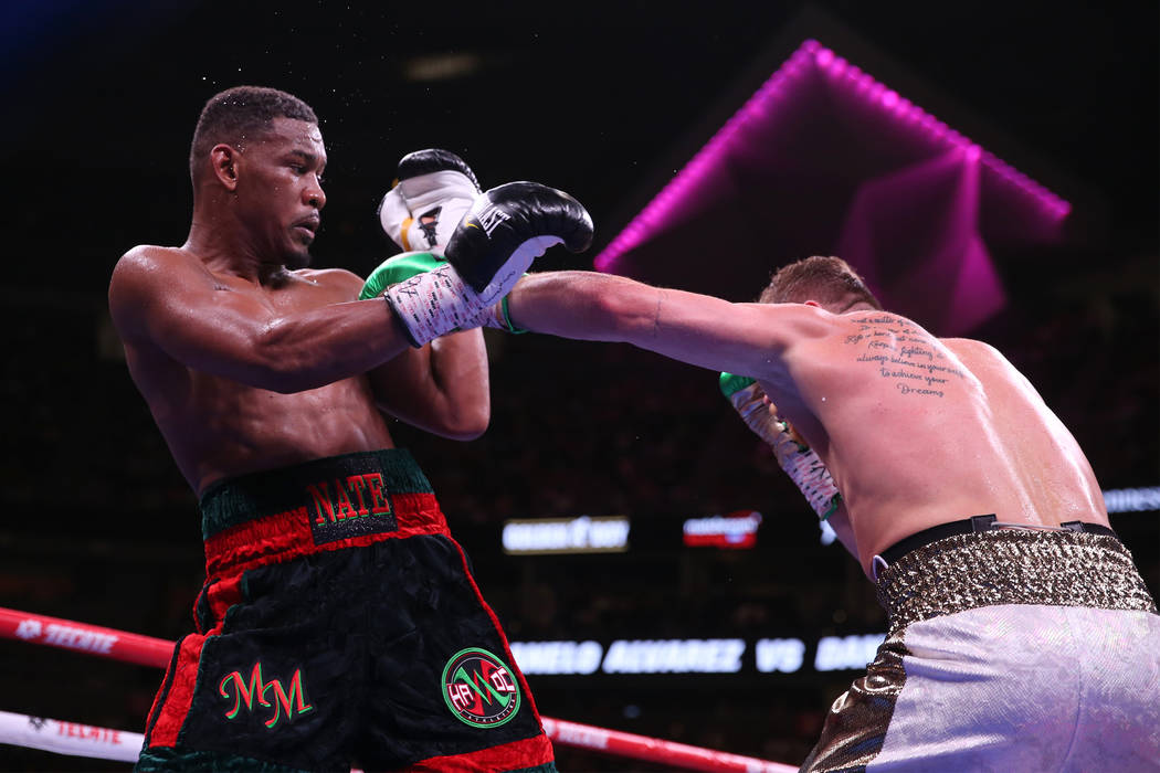 Saul Canelo Alvarez, right, throws a punch against Daniel Jacobs in the WBC, WBA, IBF, and Ring ...