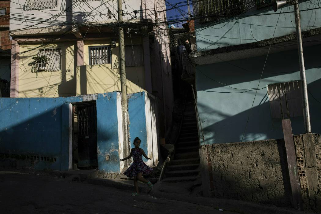 A girl runs through a neighborhood in the Petare shanty town, in Caracas, Venezuela, late Frida ...