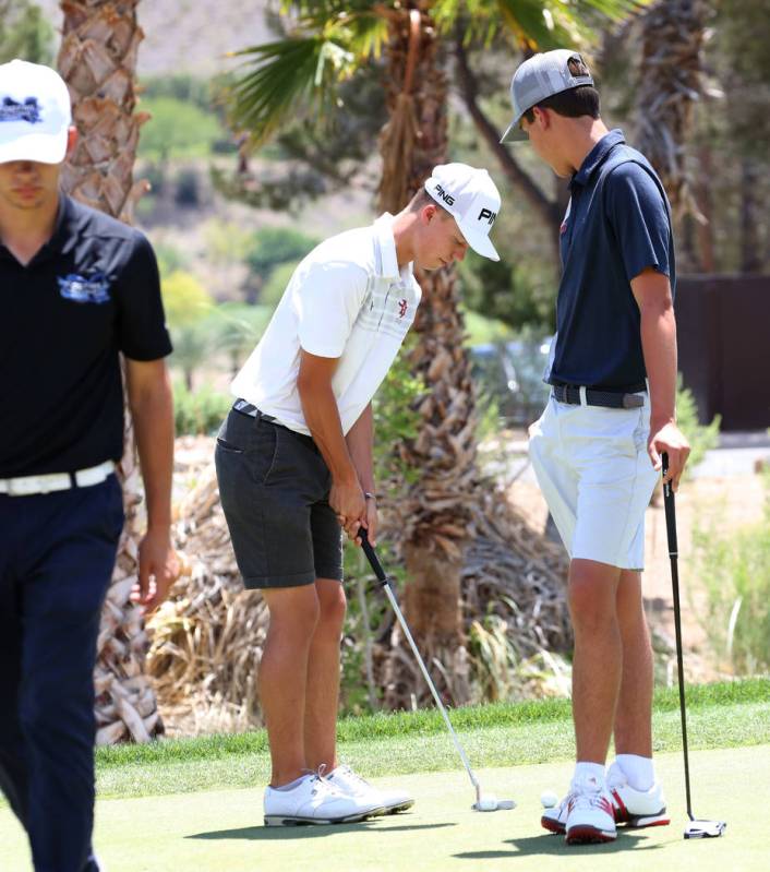 Arbor View's Hazen Newman center, practices his putting as Coronado High's Brett Sawaia looks o ...