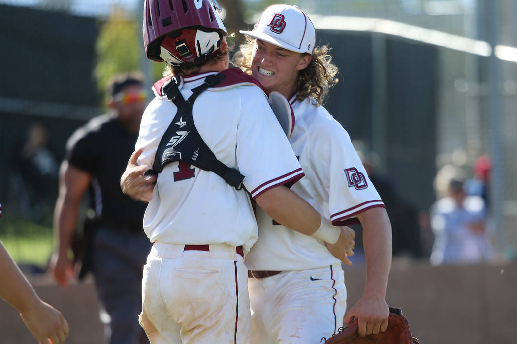 Desert Oasis' pitcher Colby Smith (11), right, embraces catcher Parker Schmidt (4) after striki ...