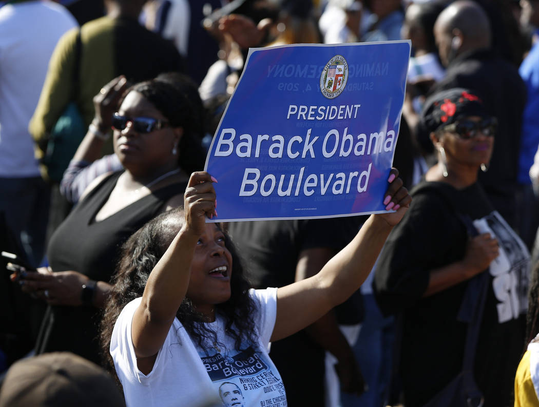 A woman holds a banner of the Obama Boulevard in Los Angeles, Saturday, May 4, 2019. The Obama ...