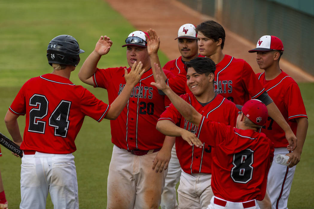 Las Vegas players celebrate a run by teammate Brady O'jeda (24) versus Reno during their state ...