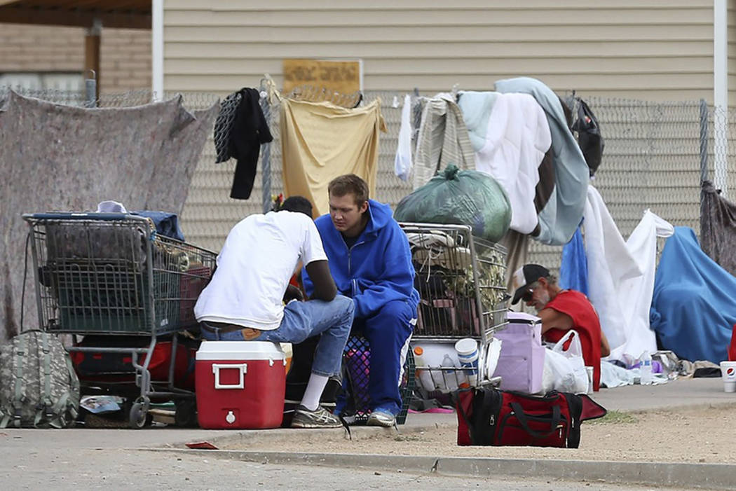 Gomeless people gather on the sidewalk at an encampment in Phoenix on May 2, 2019. (AP Photo/Ro ...