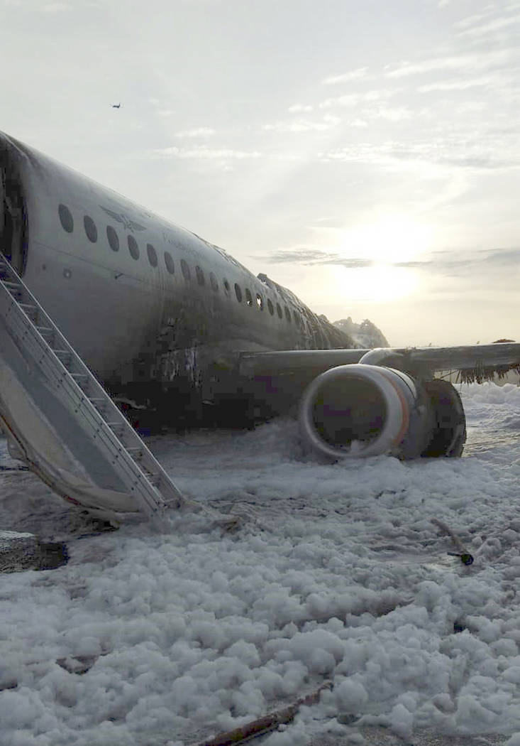 The Sukhoi Superjet 100 aircraft of Aeroflot Airlines is covered in fire retardant foam after a ...