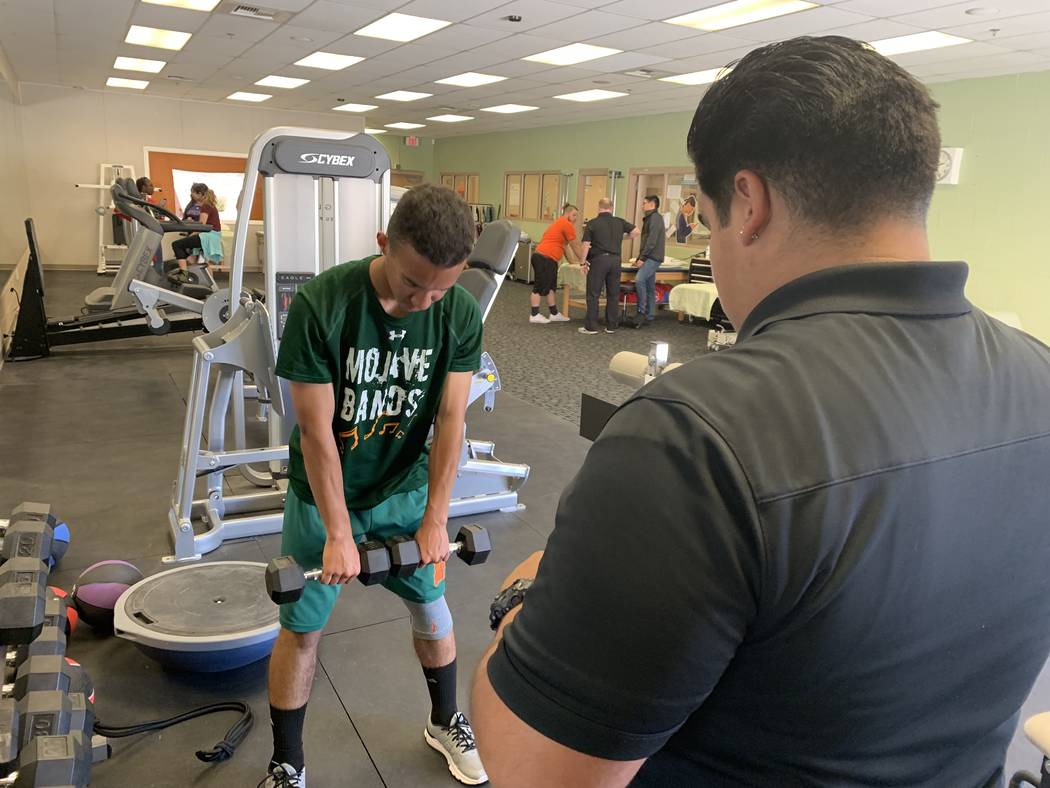 Donovan Davis, left, participates in physical therapy during his seventh period class with Ivan ...