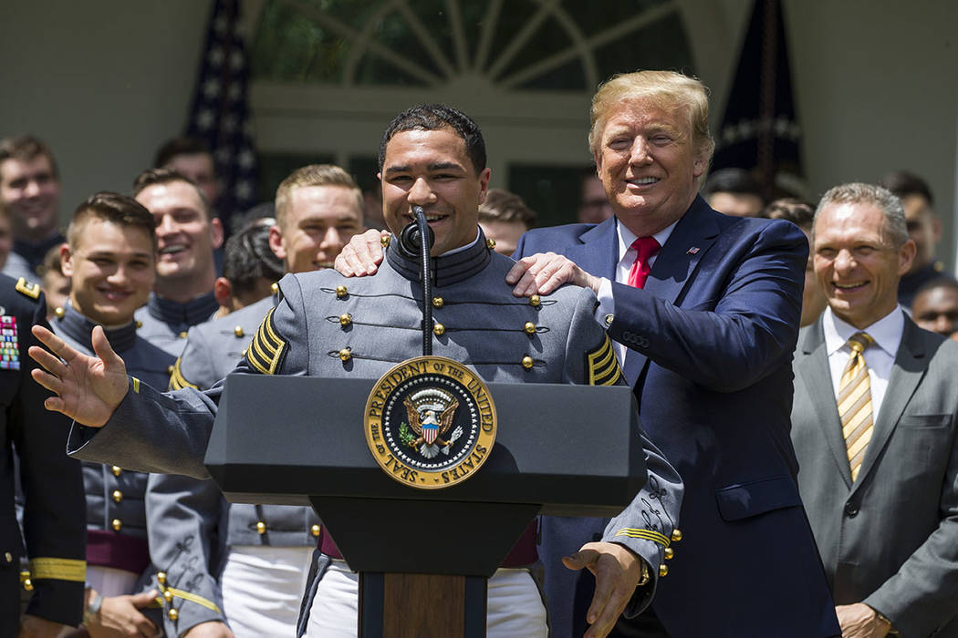 Army running back Darnell Woolfolke speaks as President Donald Trump grabs his shoulders during ...