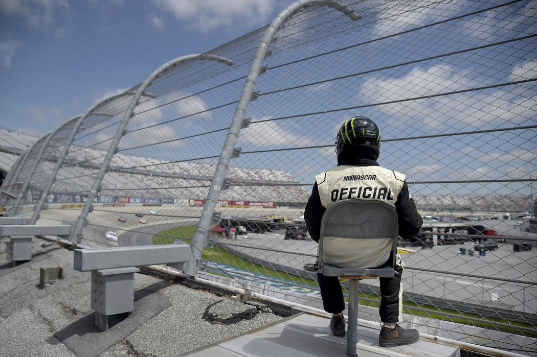 A NASCAR official looks on as drivers compete during the NASCAR Cup Series auto race, Monday, M ...