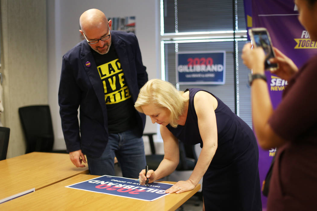 Democratic presidential candidate Sen. Kirsten Gillibrand signs a poster next to SEIU Local 110 ...