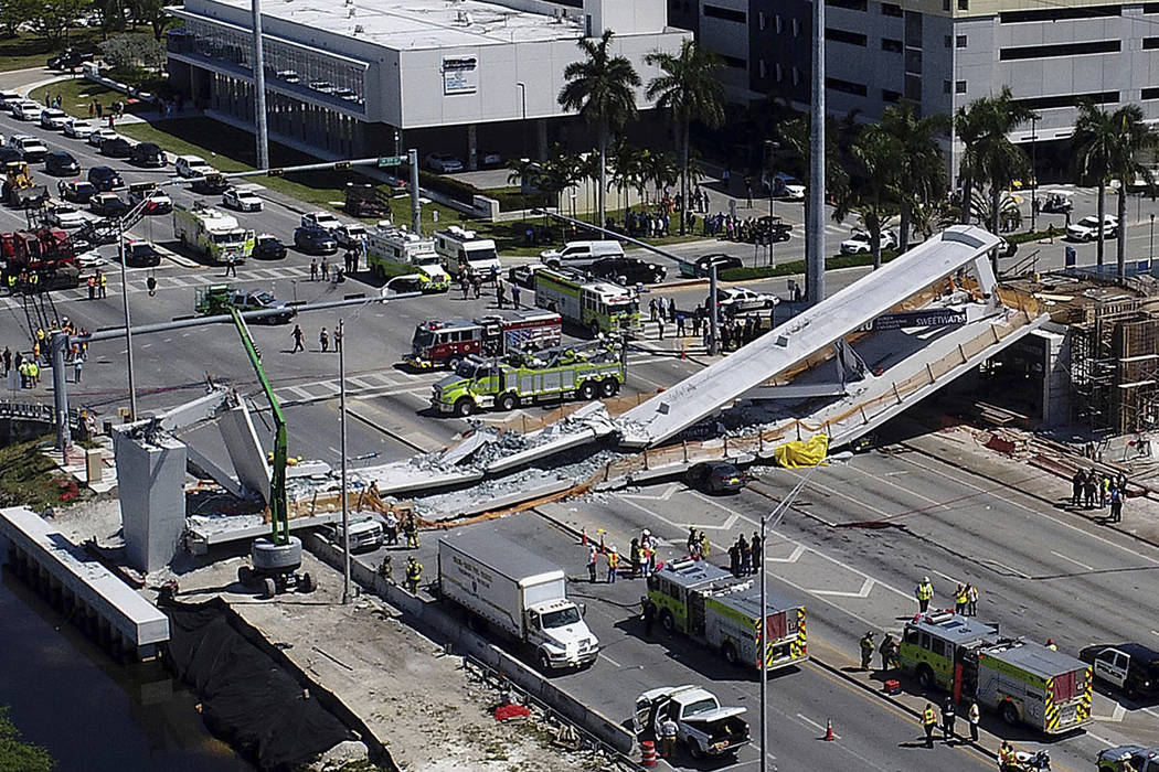 FILE - In this March 15, 2018, file photo, emergency personnel respond after a brand-new pedest ...