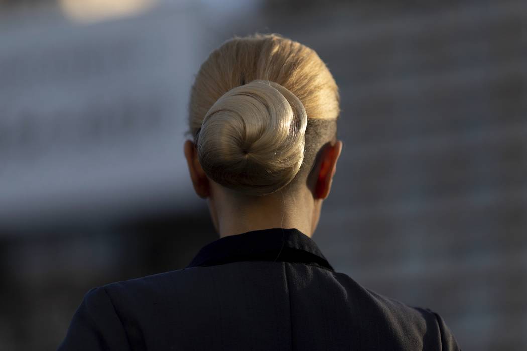 A woman wearing Eva Peron's characteristic top knot hairstyle parades in Buenos Aires, Argentin ...