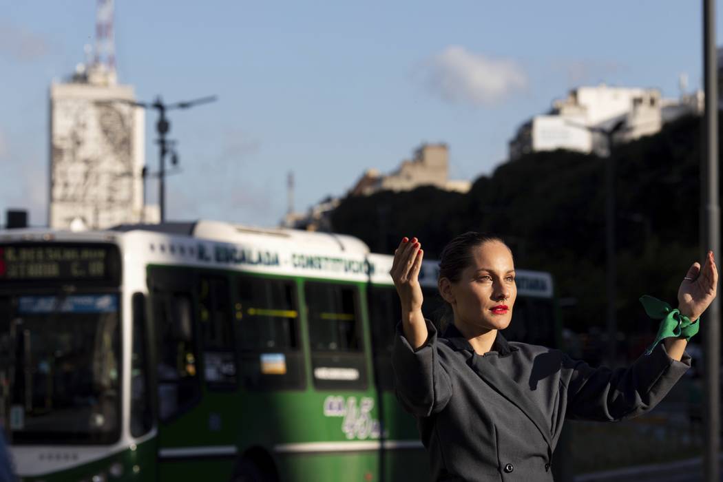 A women poses for photos dressed as Eva Peron in Buenos Aires, Argentina, Monday, May. 6, 2019. ...