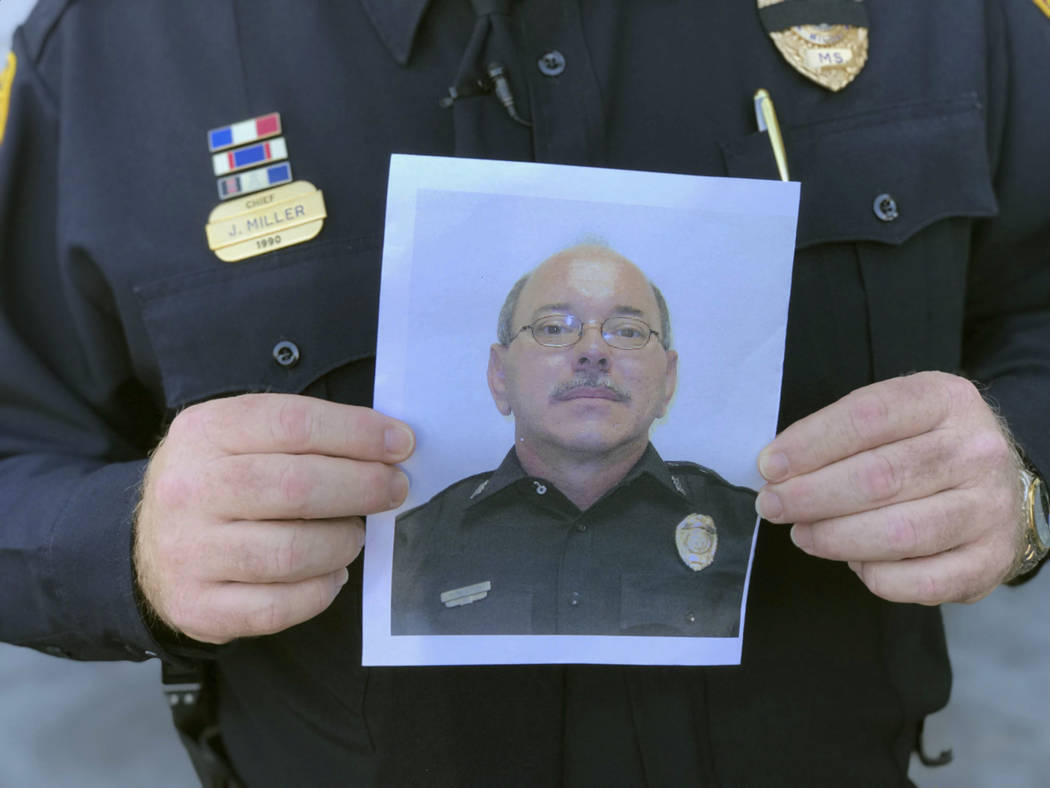 Biloxi Police Chief John Miller holds a departmental photograph of Officer Robert McKeithen who ...