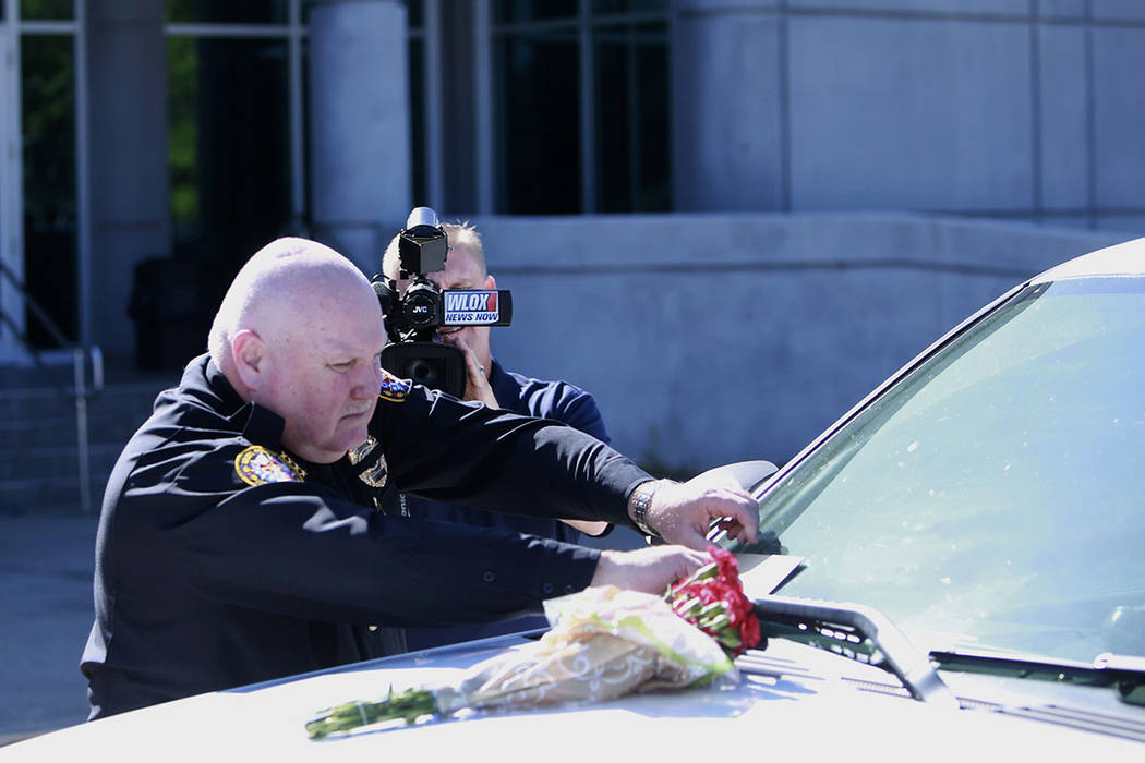 Biloxi Police Chief John Miller places flowers and a card on the police SUV of Officer Robert M ...