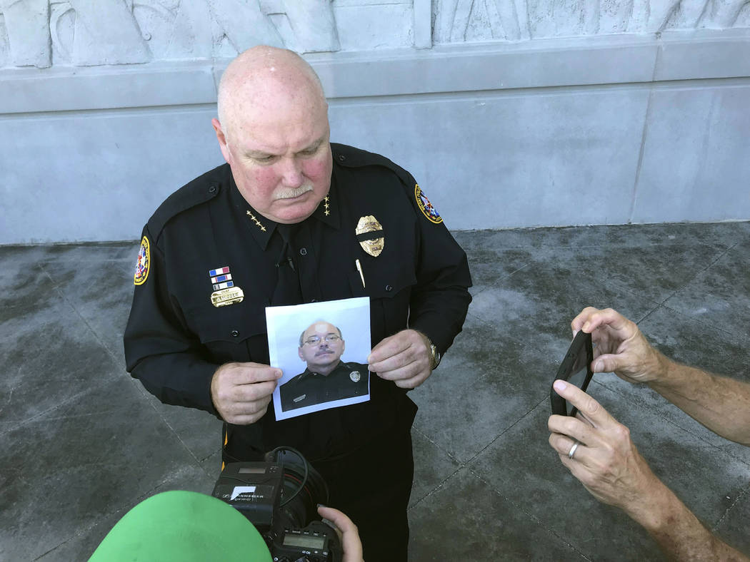 Biloxi Police Chief John Miller holds a departmental photograph of Officer Robert McKeithen who ...