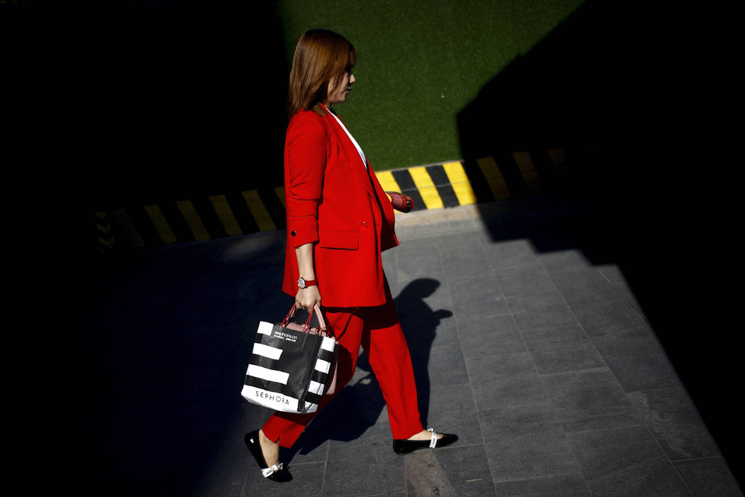 A beam of sunlight is cast on a woman on her way to work at the Central Business District in Be ...