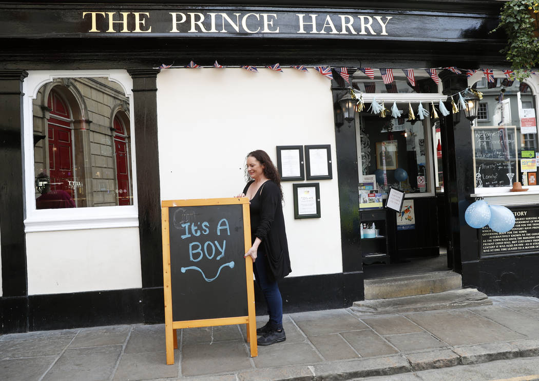 A publican displays a board outside the Prince Harry pub, in Windsor, south England, Tuesday, M ...