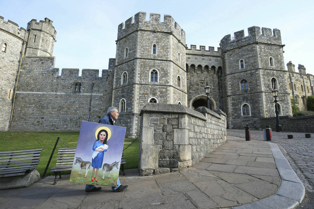 Political artist Kaya Mar walks with his latest work past Windsor Castle in Windsor, England, f ...