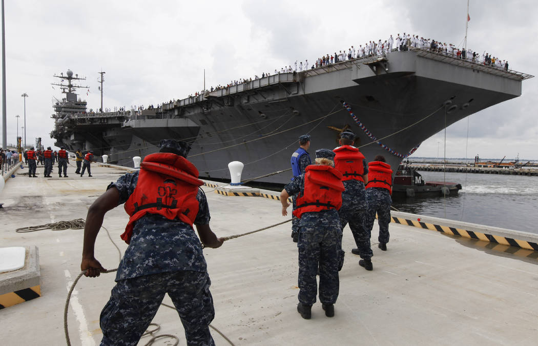 FILE - In this Aug. 7, 2012, file photo, Navy shore crew haul in lines as the nuclear powered a ...