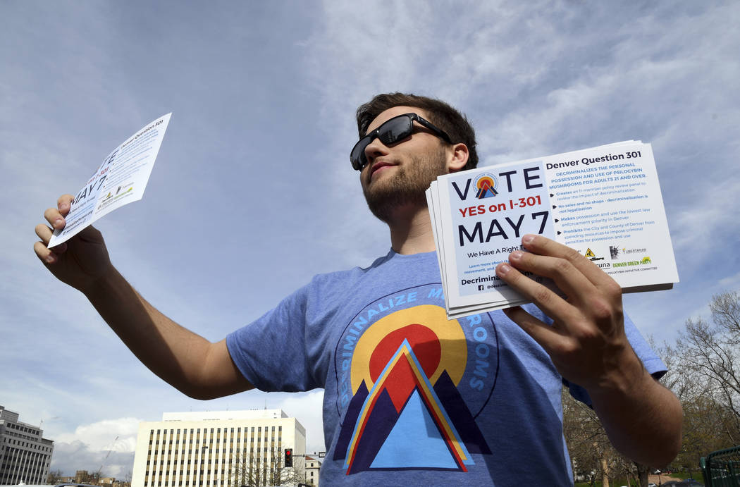 Taylor Tongate, of Monterey, Calif., holds flyers at an intersection in downtown Denver on Mond ...