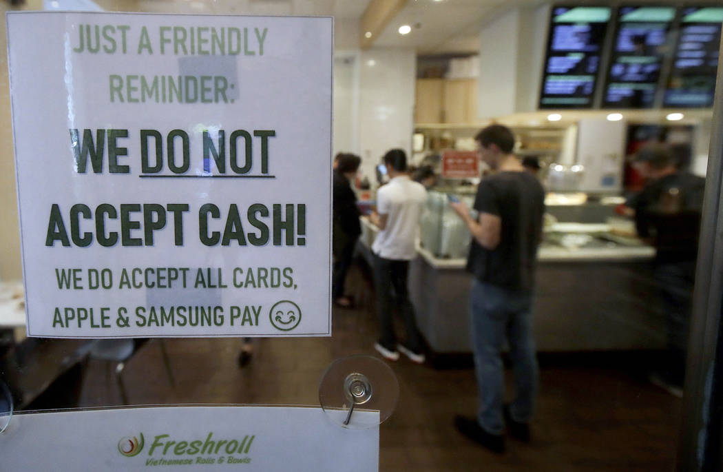 A sign posted on a door May 2, 2019, alerts customers that cash is not accepted at Freshroll Vi ...