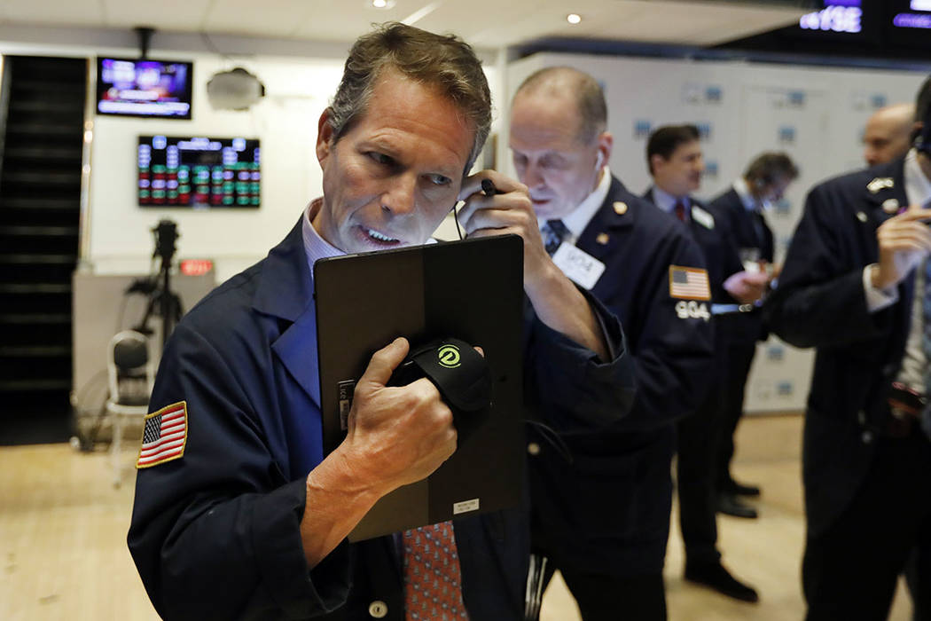 Trader Robert Charmak, left, works on the floor May 1, 2019, of the New York Stock Exchange. (A ...