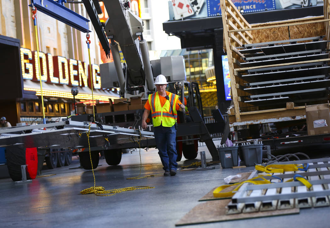 Construction workers prepare to installl a new panel during the second day of renovations of th ...