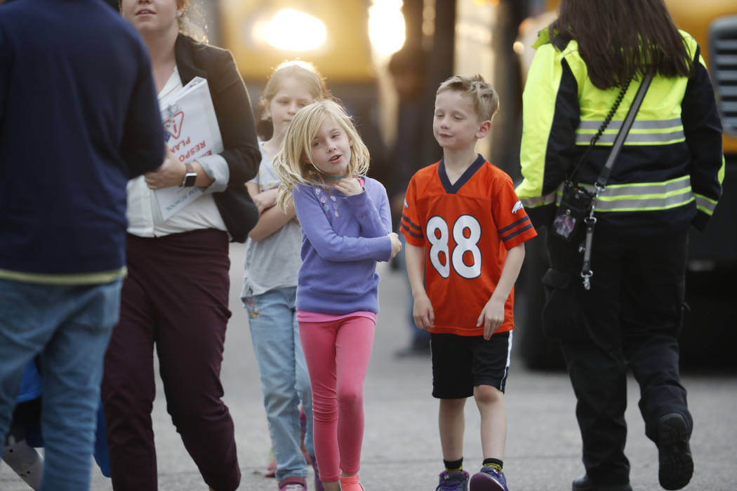 Students follow their teacher off a bus and into a recreation center where they were reunited w ...