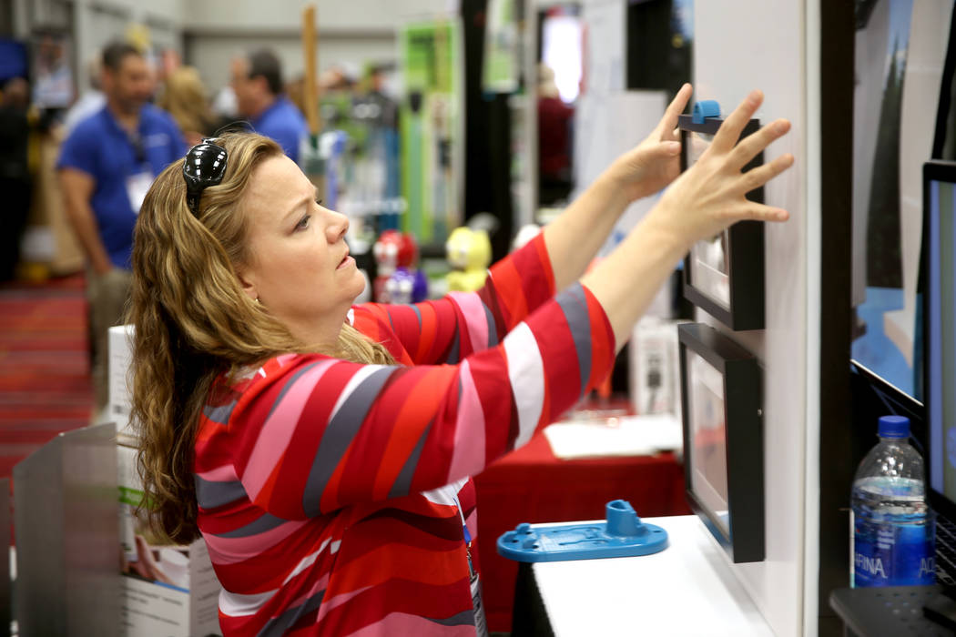 Shari Hammond, of Georgetown, Texas, demonstrates her Go Hang It invention in the Inventors Spo ...