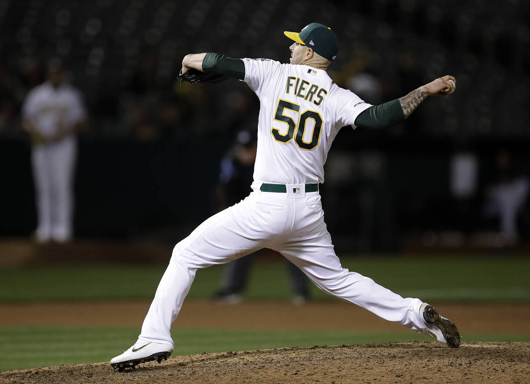 Oakland Athletics' Mike Fiers works against the Cincinnati Reds in the ninth inning of a baseba ...