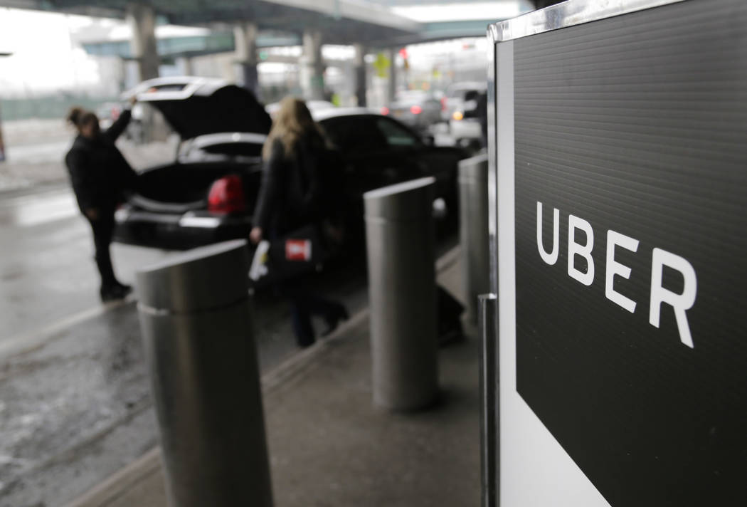 A sign marks a pick-up point for the Uber service at LaGuardia Airport in New York on March 15, ...