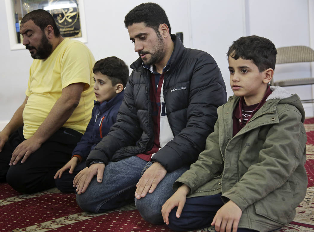 In this Thursday, March 21, 2019, photo, Sadek Ahmed, second from right, prays with his sons Ad ...