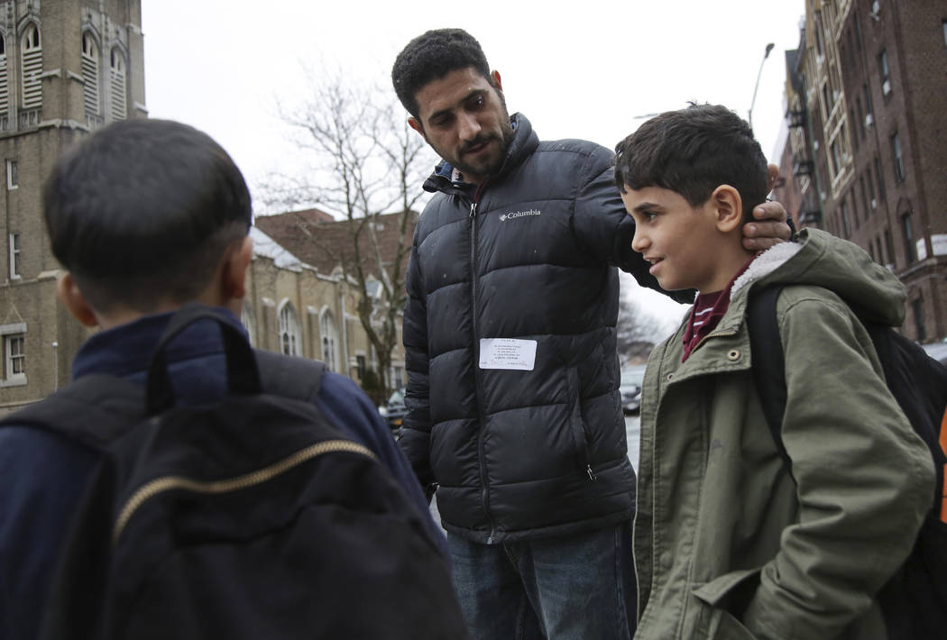 In this Thursday, March 21, 2019, photo, Sadek Ahmed walks with his sons Adel, 9, right, and Mu ...