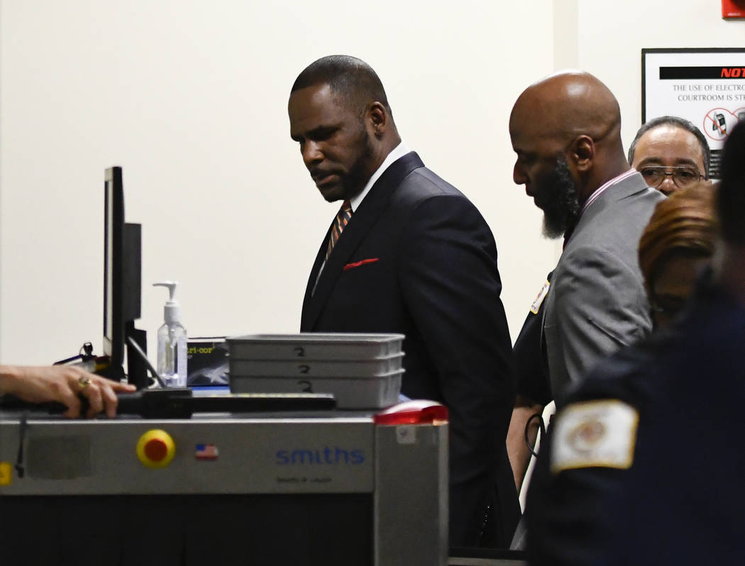 Musician R. Kelly, center, goes through security after he arrives at the Daley Center for a hea ...