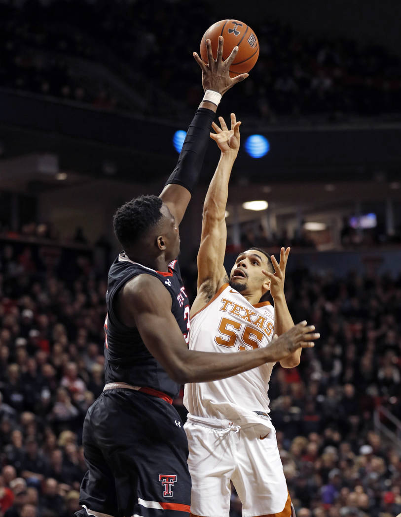 Texas Tech's Norense Odiase (32) tries to block the shot by Texas' Elijah Mitrou-Long (55) duri ...