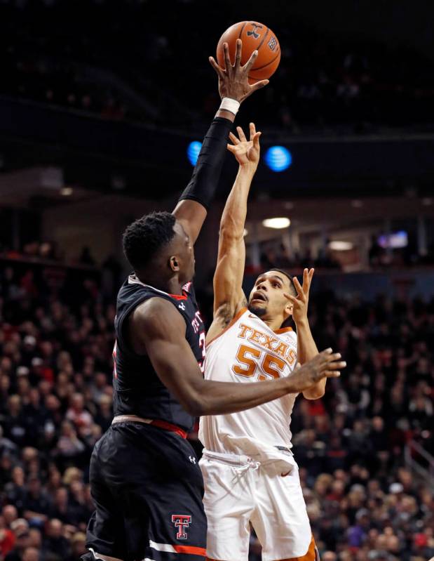 Texas Tech's Norense Odiase (32) tries to block the shot by Texas' Elijah Mitrou-Long (55) duri ...