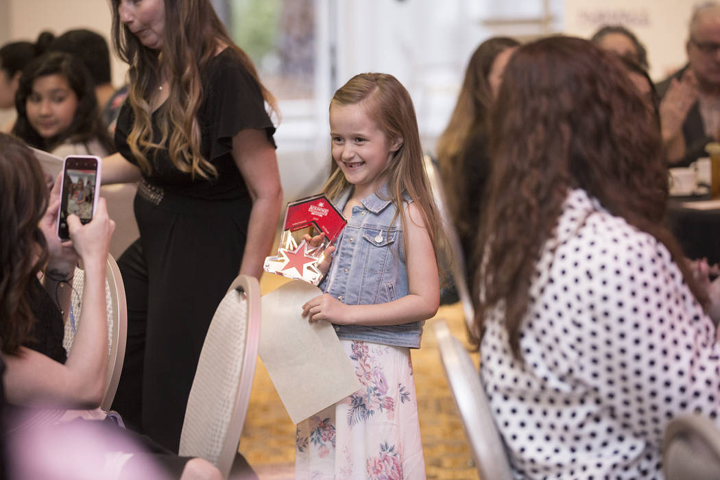 Award winner Sofia Frasier, middle, a first grader at Scherkenbach Elementary School, walks bac ...