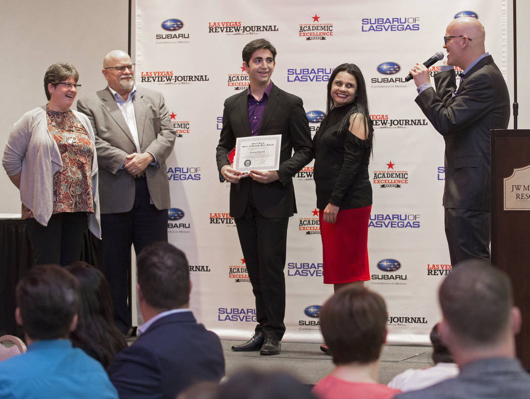 Samuel Grant, third from left, an eleventh grader at Coral Academy of Science, stands on stage ...