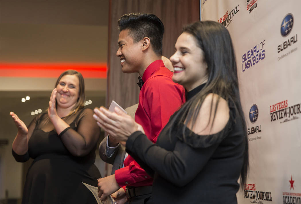 Award winner Shaun Mabanta, middle, a twelfth grader at Liberty High School, celebrates with La ...