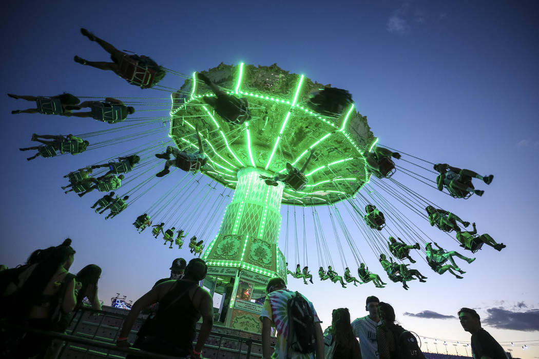 Festivalgoers swing on a fairground ride on day one of the Electric Daisy Carnival at the Las V ...