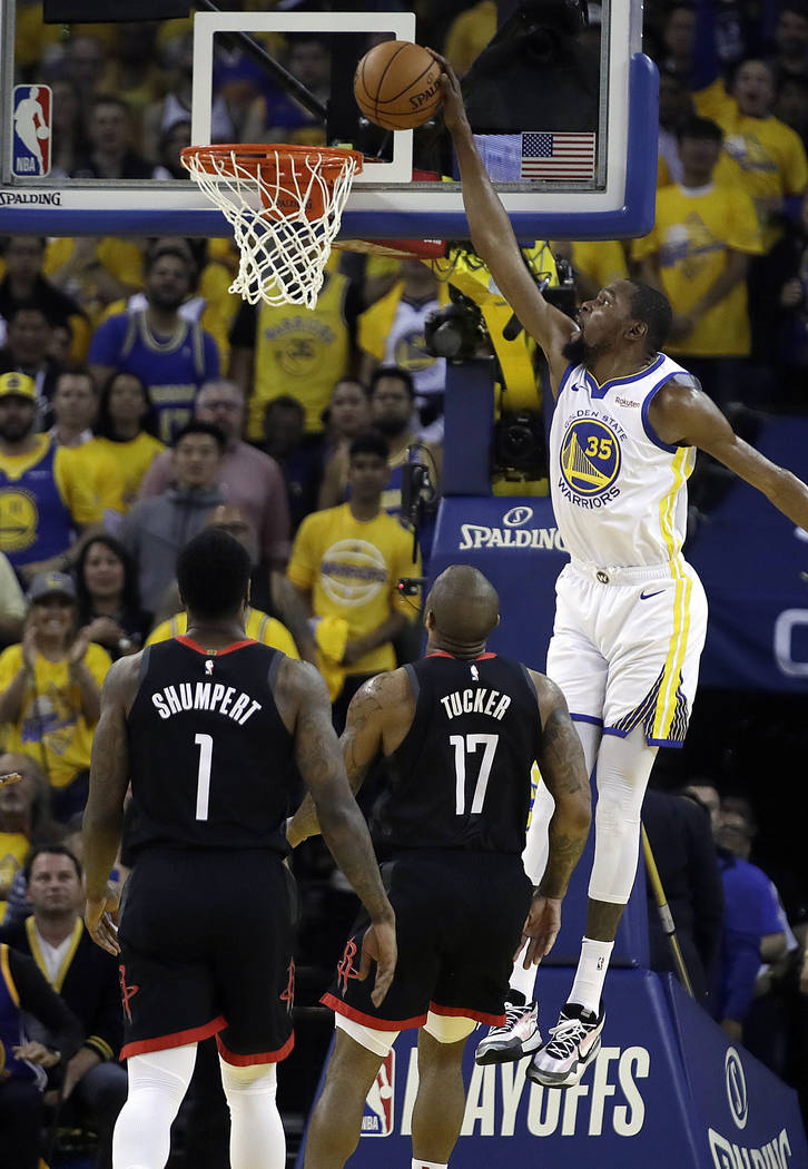 Golden State Warriors' Kevin Durant, right, scores over Houston Rockets' PJ Tucker (17) and Ima ...