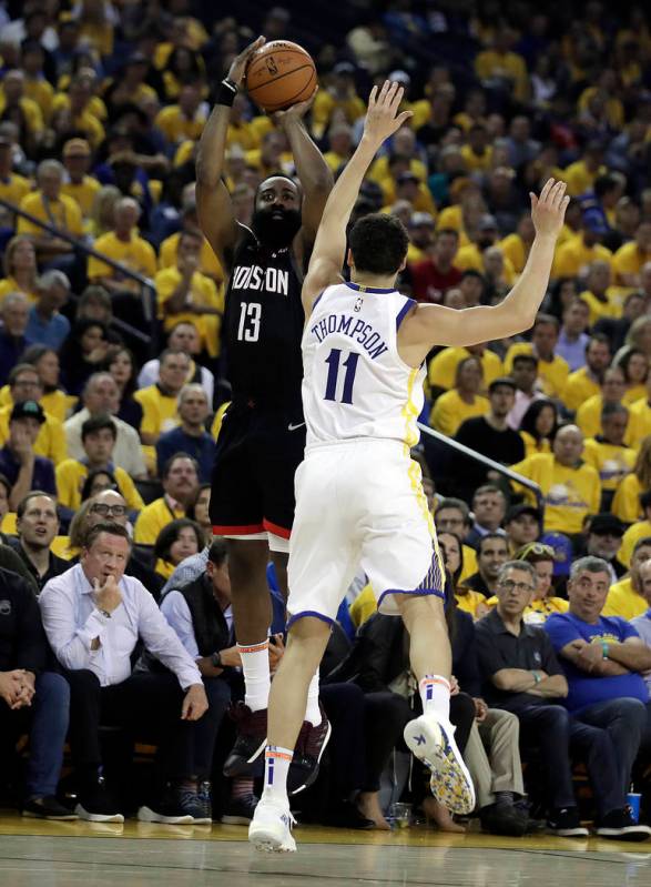 Houston Rockets' James Harden, left, shoots against Golden State Warriors' Klay Thompson (11) d ...