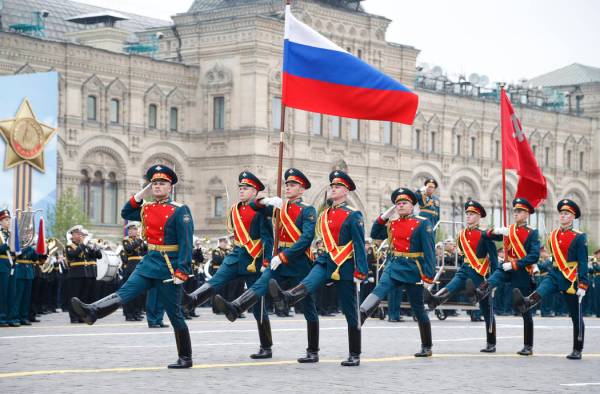 Russian honour guard carry a national flag, left, and a replica of the Victory banner during th ...