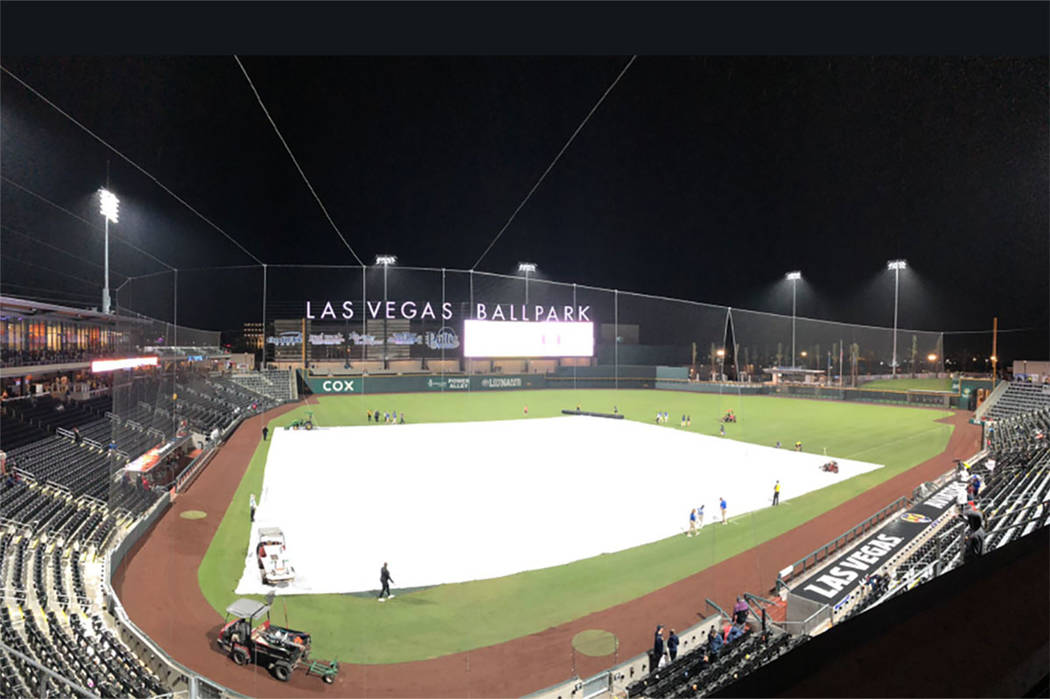 Crews cover the field during a rain delay at Las Vegas Ballpark during a Las Vegas Aviators gam ...