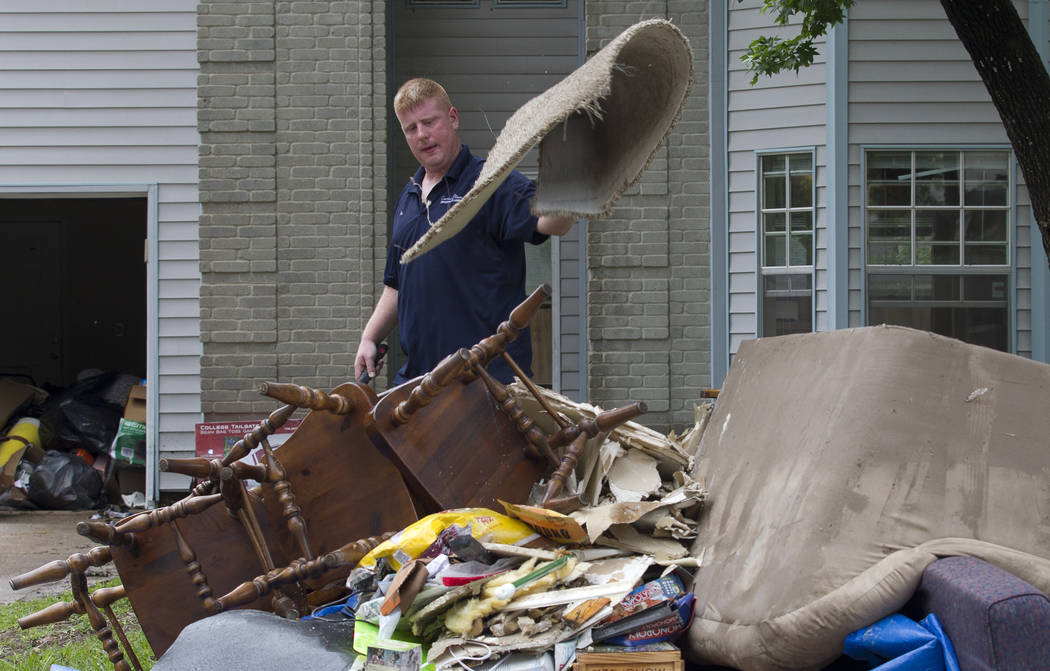 Jay Dabravio throws a matt onto a pile at the front of his house in the Sherwood Trail subdivis ...