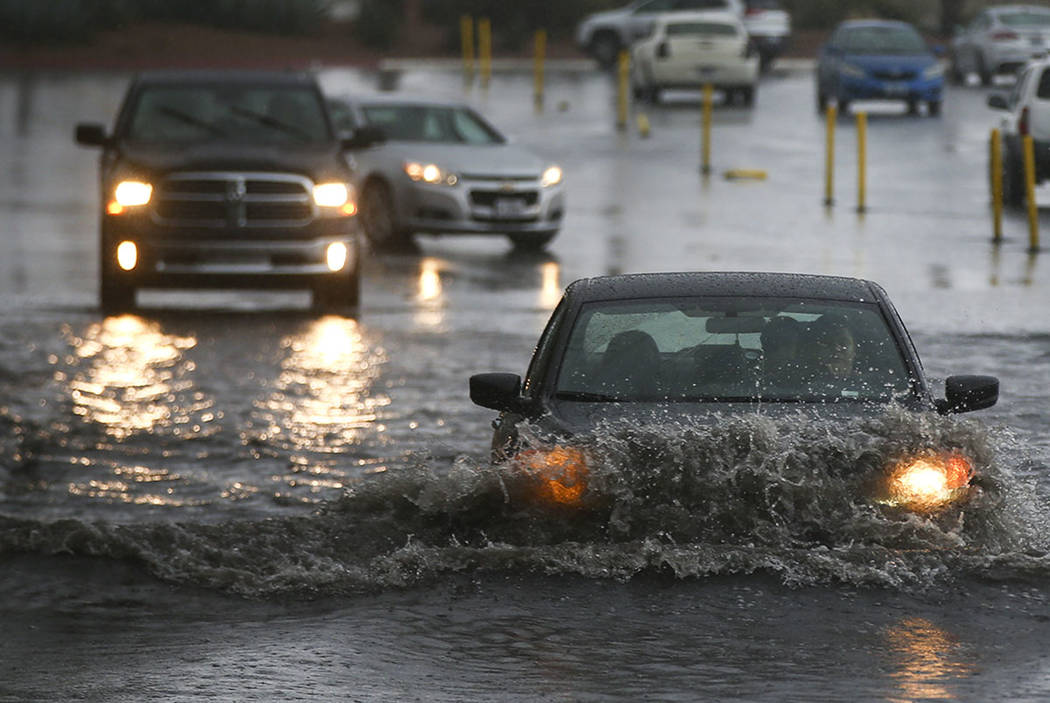 People navigate a flooded parking lot at UNLV in Las Vegas on Saturday, Feb. 18, 2017. (Chase S ...