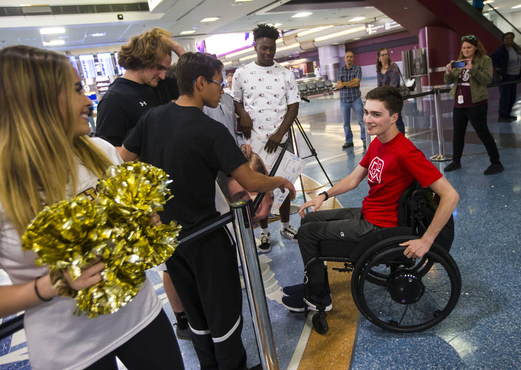 Faith Lutheran senior Mark Wilbourne, in red, greets friends at McCarran International Airport ...