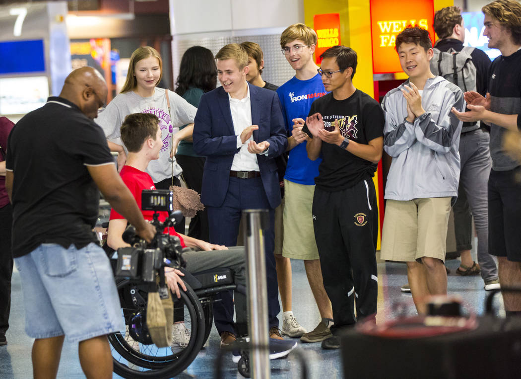 Friends cheer for Faith Lutheran senior Mark Wilbourne, in red, as he reacts to a welcome party ...