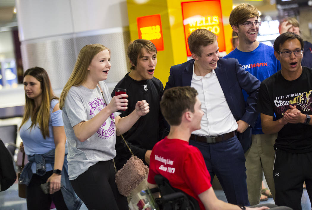 Friends cheer for Faith Lutheran senior Mark Wilbourne, in red, as he reacts to a welcome party ...