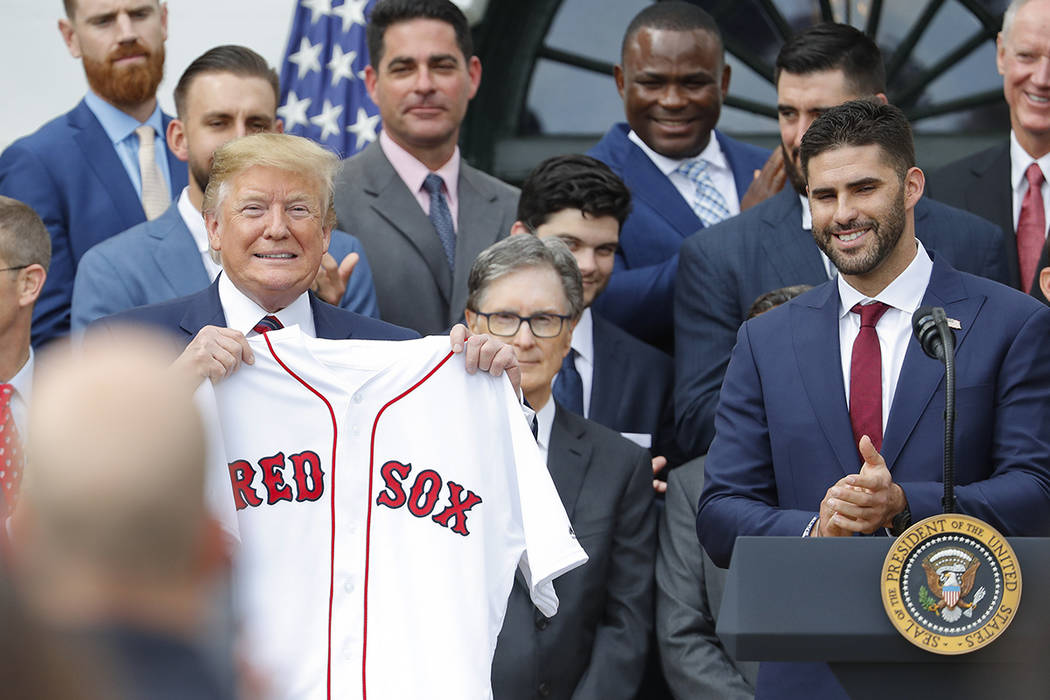 President Donald Trump, left, holds a team jersey that was presented to him by outfielder J.D. ...